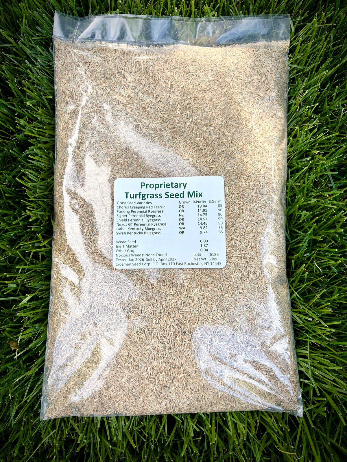 Bag of proprietary turfgrass seed mix on grass